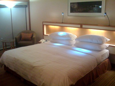 A neatly made bed with white pillows and covers.
