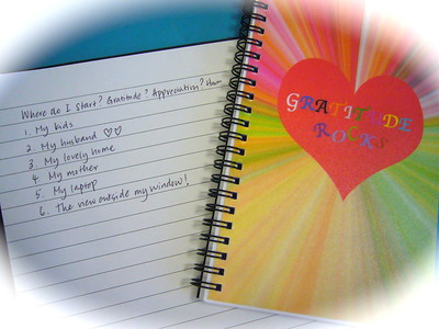 A journal shows a list of things someone is grateful for next to another colorful journal that says "gratitude rocks."