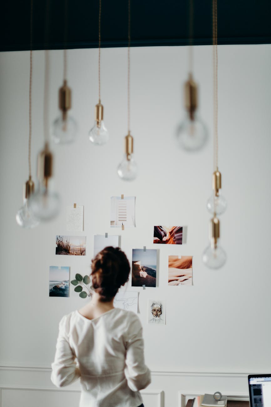 A woman looks at nature photos hung on a white wall.