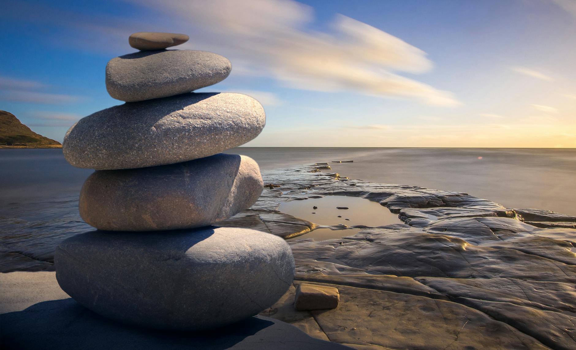 A stack of rocks sit on a seashore.
