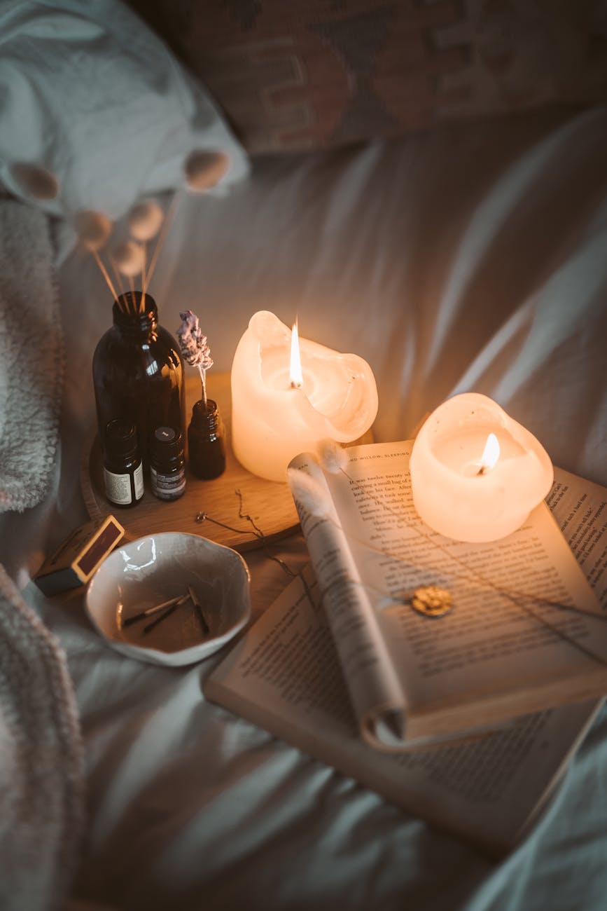 Books and candles on a bed.
